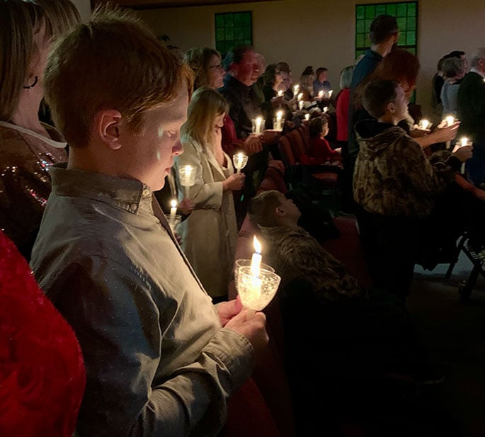 people praying together with candle light