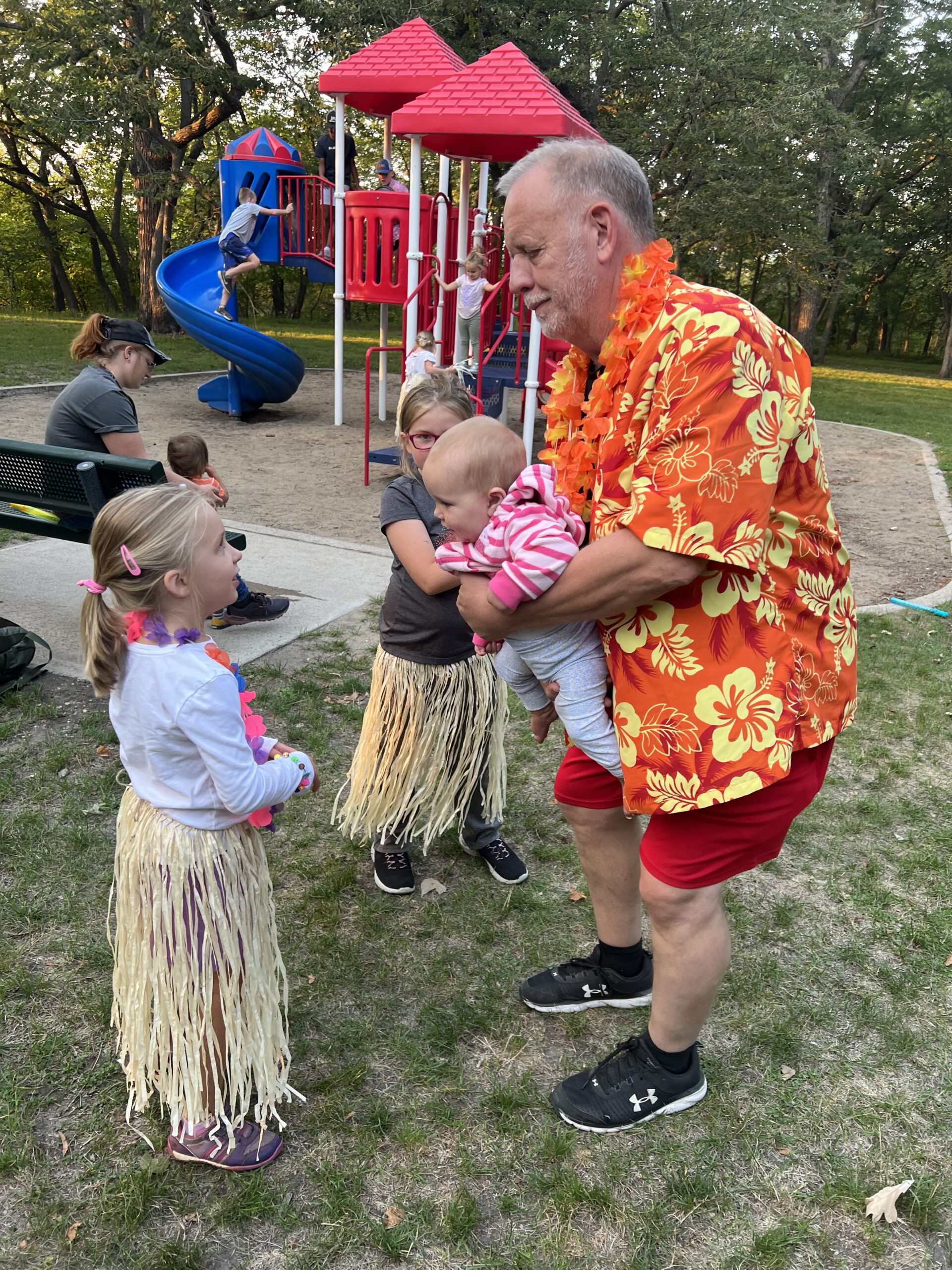 a man holding a baby and talking to a girl at kids club at cornerstone